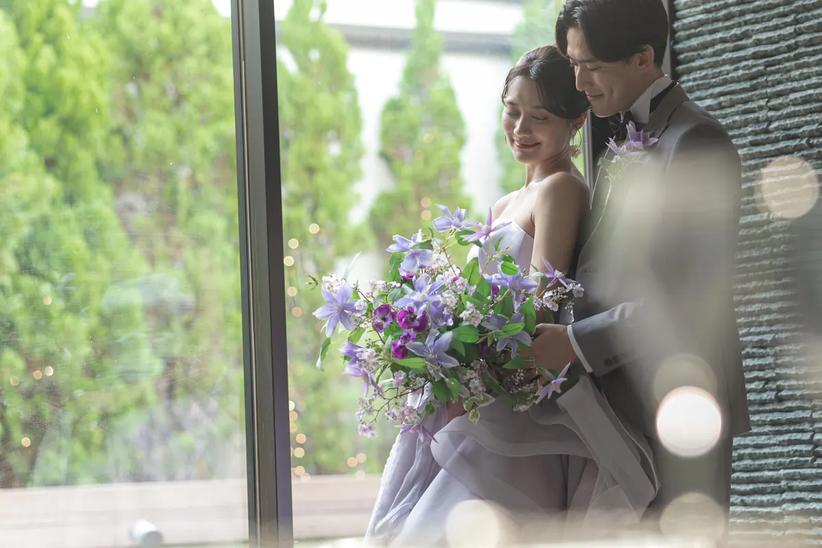 窓辺で寄り添う新郎新婦