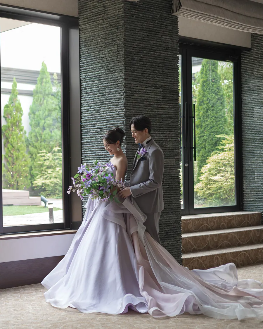 会場オペラの大きな窓の前に立つ新郎新婦